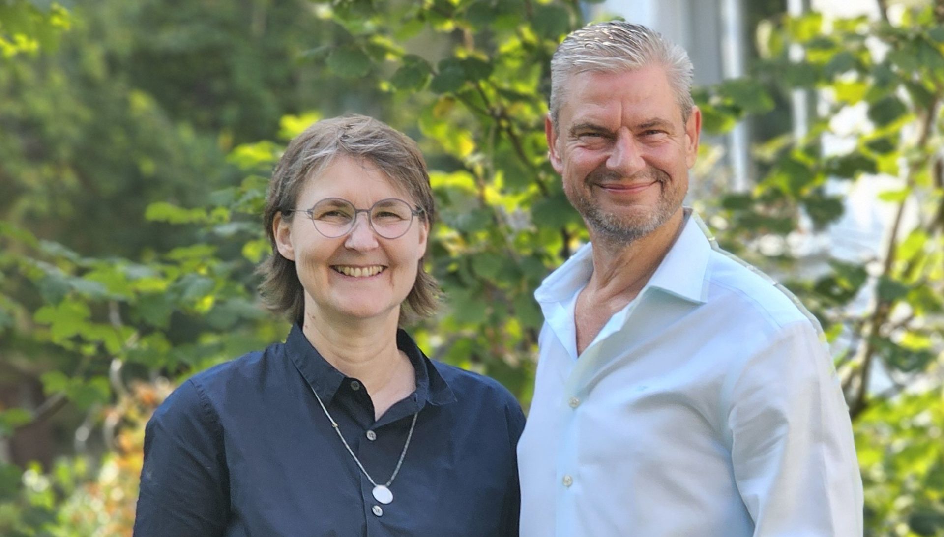 Wiebke Papenthin und Ingo mit sonnigem Gartenhintergrund